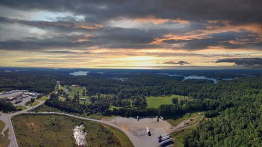 a stunning aerial panoramic shot of the blue waters of Lake Hartwell surrounded by vast miles of lush green trees and grass with powerful clouds at sunset in Fair Play South Carolina USA