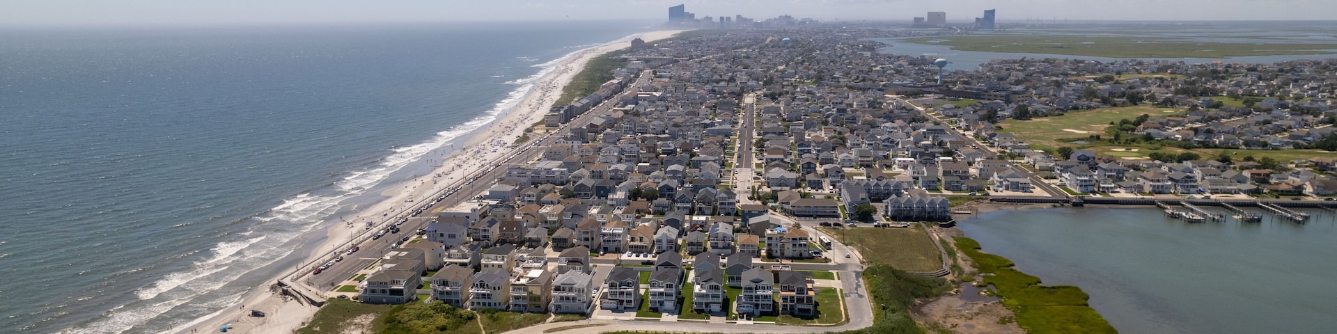 Una ciudad costera con playa, zonas residenciales y un puerto deportivo.