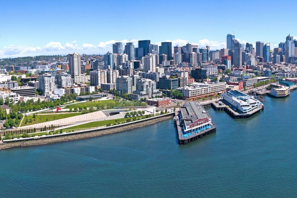 A city skyline with a prominent tower, waterfront, and a ferry dock.