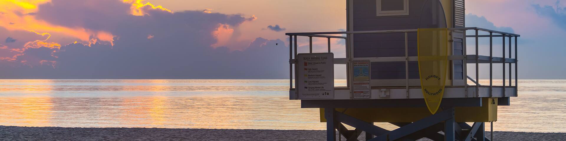 Miami beach, Florida lifeguard building hut by Atlantic ocean coast at sunrise with nobody on sand and still water reflection