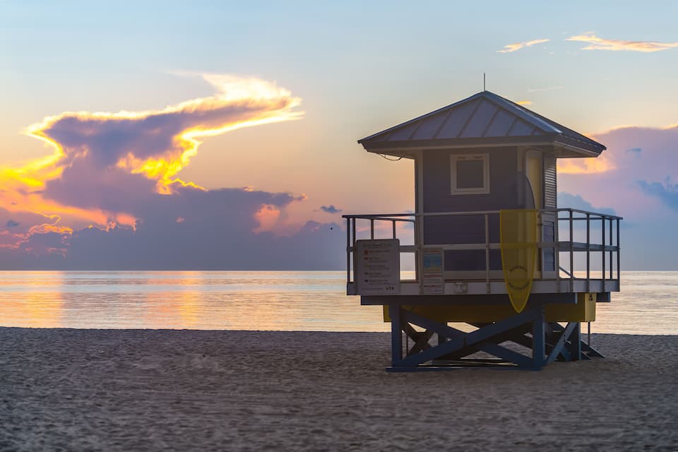 Een redderpost op het strand, met een zonsondergang op de achtergrond.