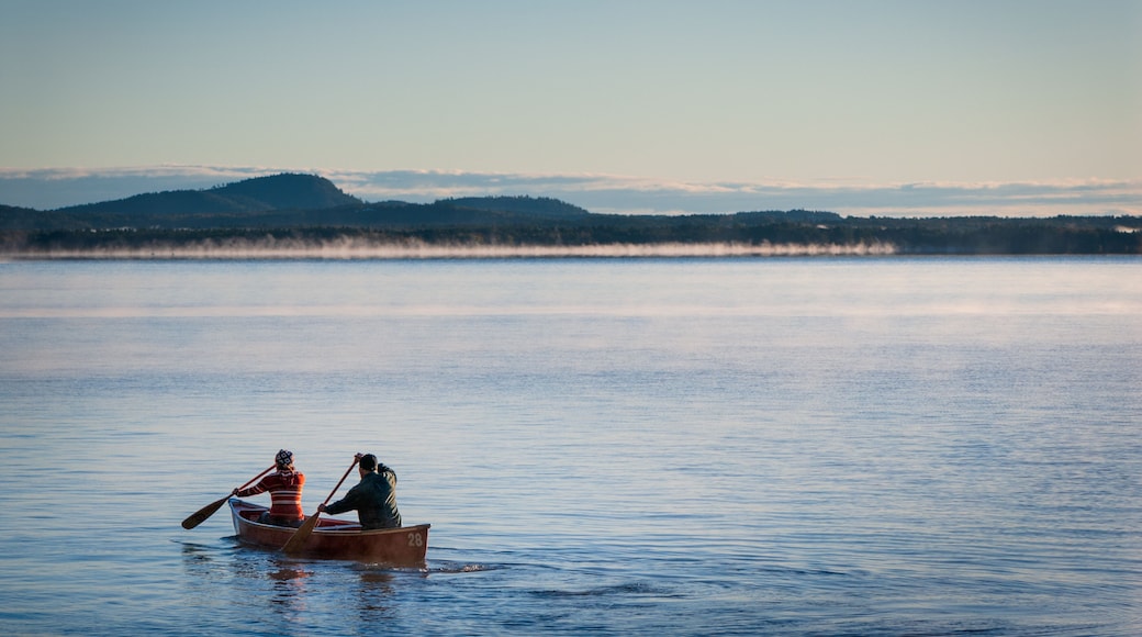 A man and woman paddle a canoe at Sebago Lake, Maine