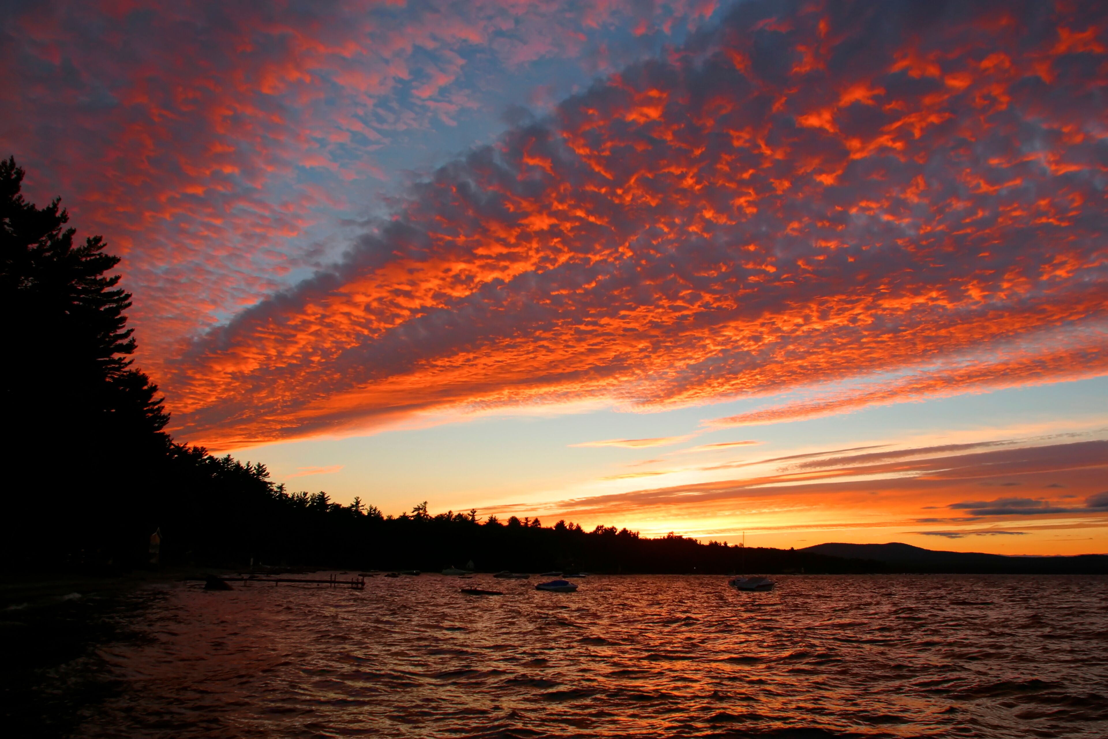 Golden clouds over Sebago Lake at sunset.; Sebago Lake, Maine.