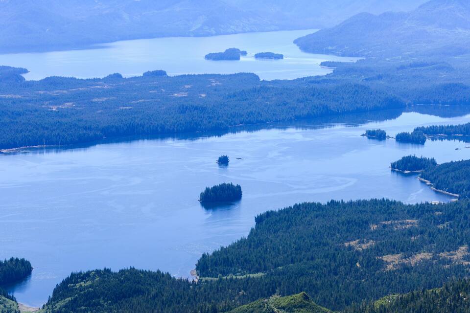 A large lake surrounded by dense forests and mountains.