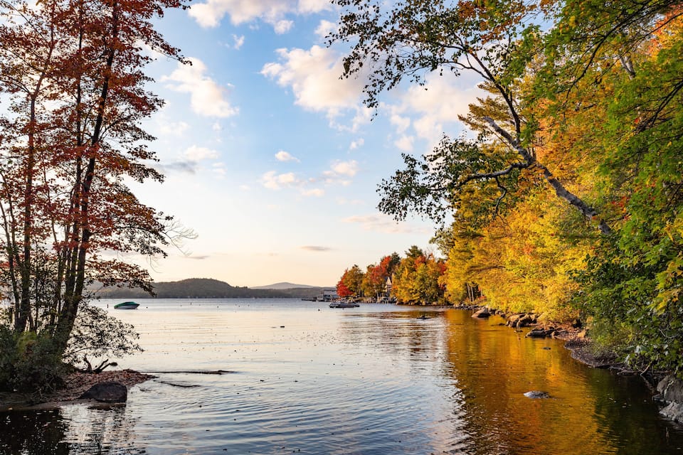 A calm lake surrounded by autumn-colored trees.
