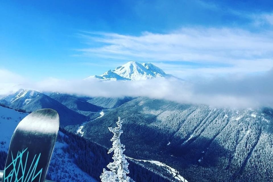 Et snedækket bjerglandskab med et snowboard forrest.