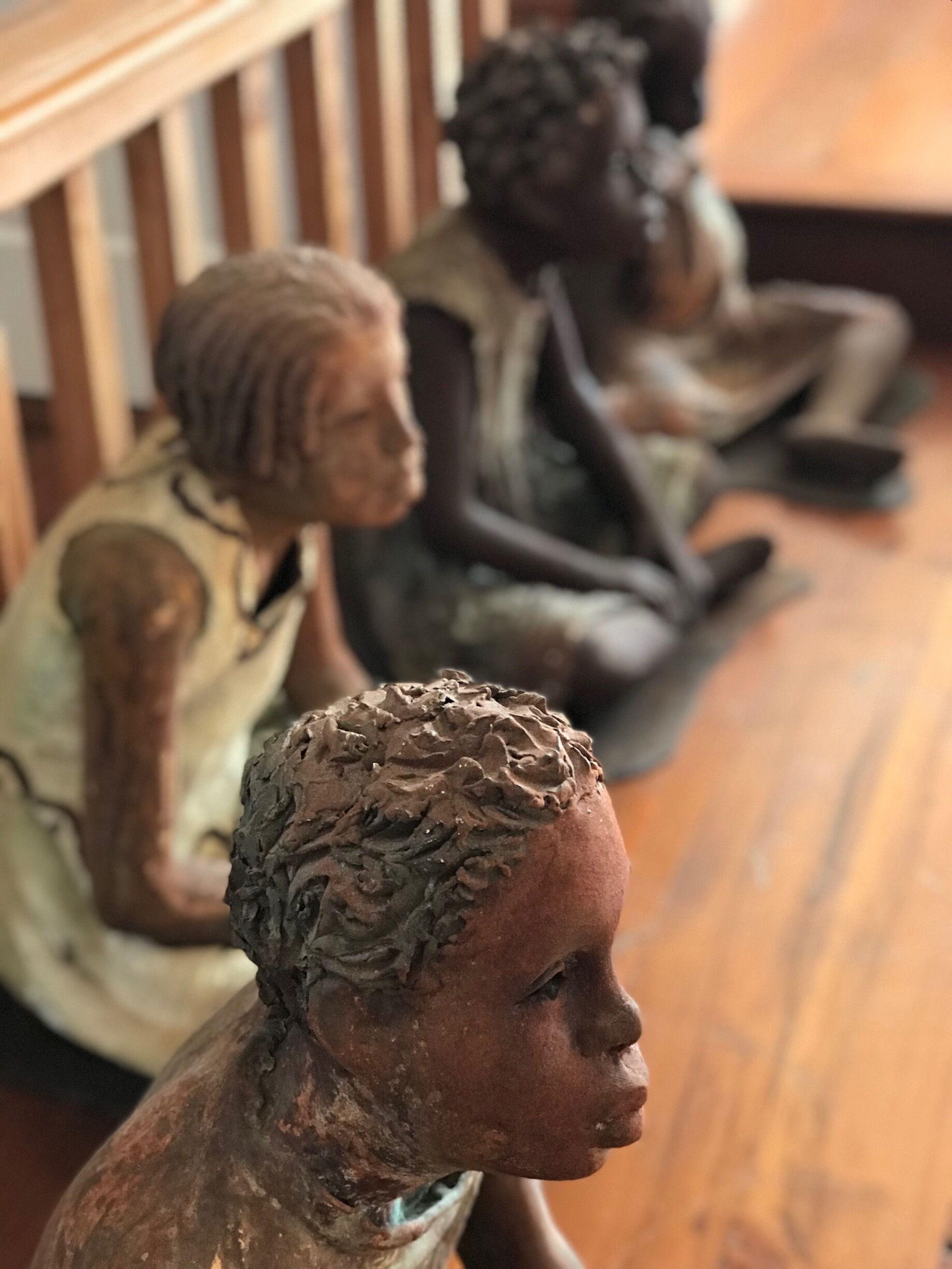 A row of bronze sculptures of seated figures.
