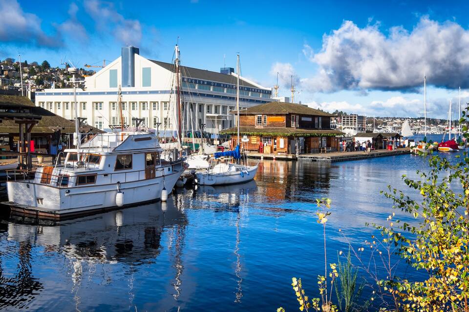 A harbor with boats docked, a museum, and a waterfront building.