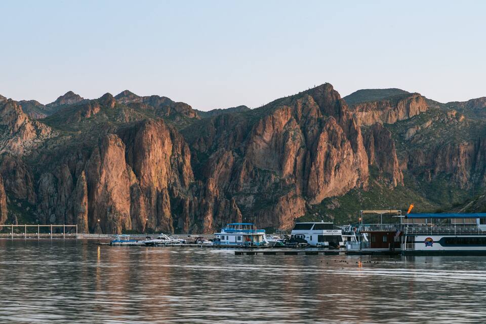 A harbor with boats and a large mountain range in the background.