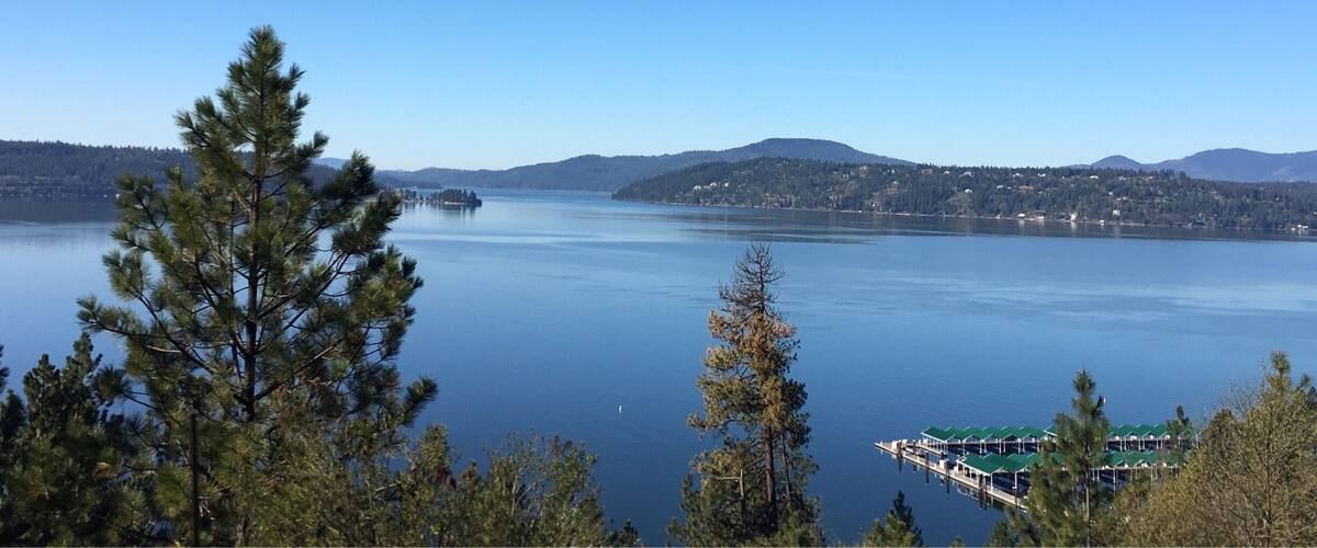A calm lake surrounded by mountains and trees.