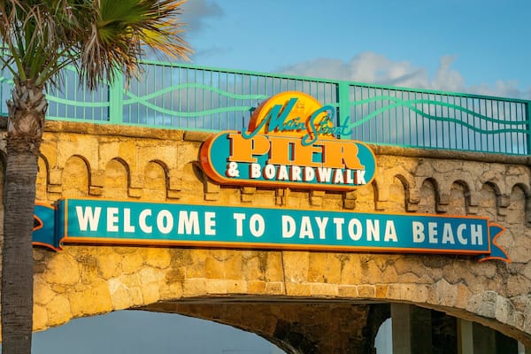 A stone bridge with a sign reading "Welcome to Daytona Beach" and another sign for "Myrtle Street Pier & Boardwalk".