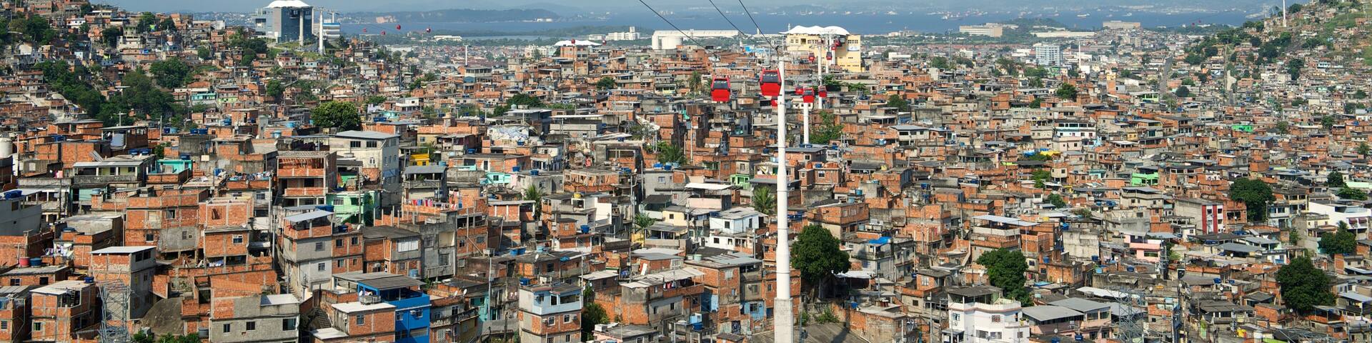 A cityscape with red cable cars against a clear sky.