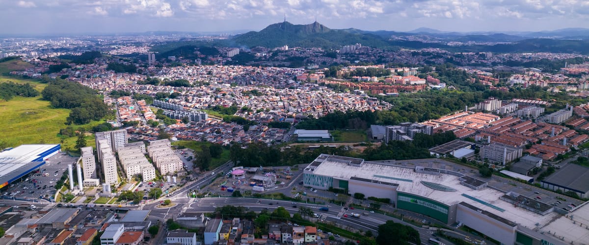 A cityscape with a prominent mountain in the background, a large industrial area, and a densely populated urban center.