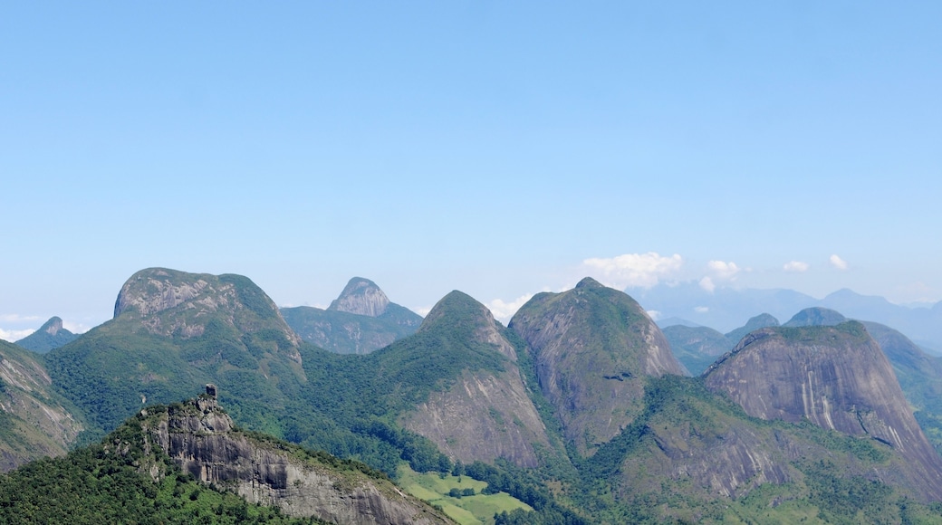 A mountainous landscape with prominent peaks and a rocky outcrop in the foreground.