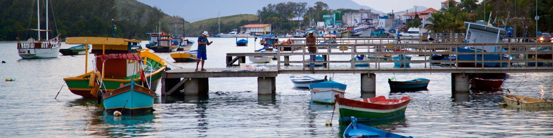 Cabo Frio featuring a coastal town and a bay or harbor as well as an individual male