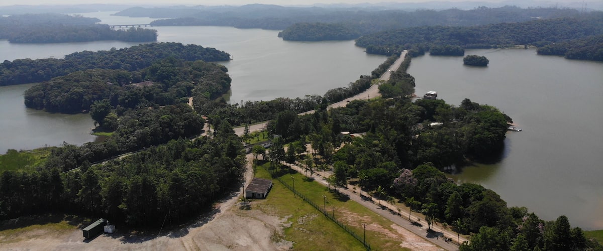 A river winding through a forested landscape with a bridge and a road.