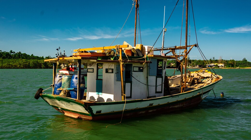 A fishing boat on calm water with a clear sky.