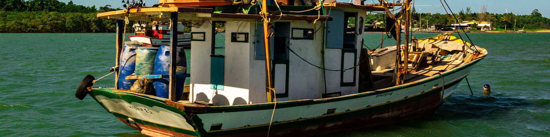 A fishing boat on calm water with a clear sky.