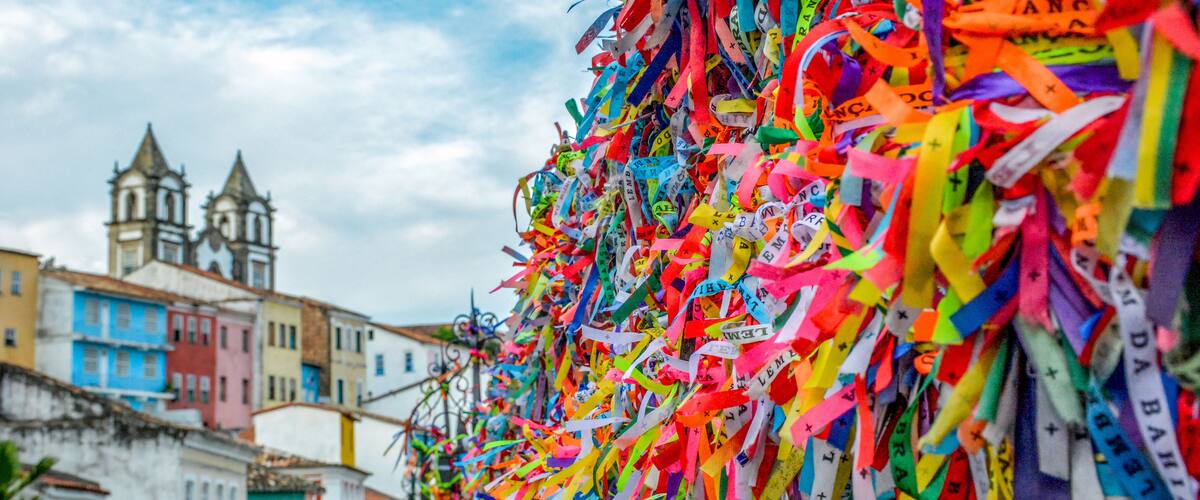 Um conjunto colorido de fitas e etiquetas, com uma igreja histórica e edifícios coloridos ao fundo.
