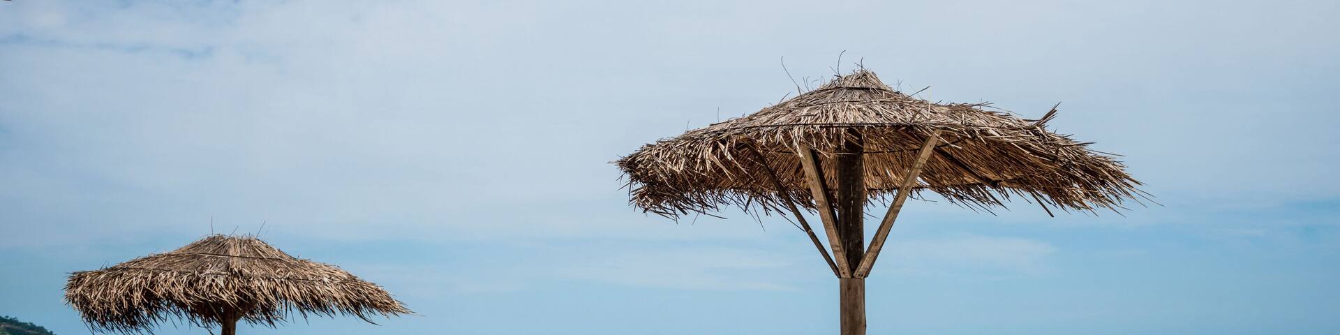 Straw parasol and chairs on Praia do Grumari, Grumari beach, west zone, Rio de Janeiro, Brazil.