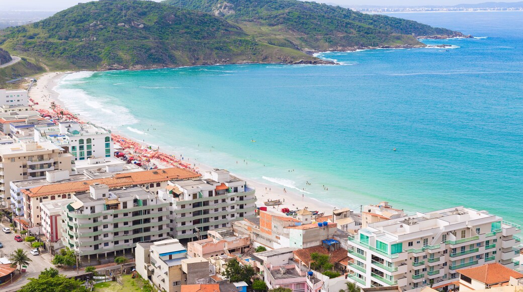 Coastline over paradise beach destination. Hotels, beach umbrellas, and mountains in the background. The water is refreshingly turquoise. Praia dos Anjos in small town Arraial do Cabo in Brazil