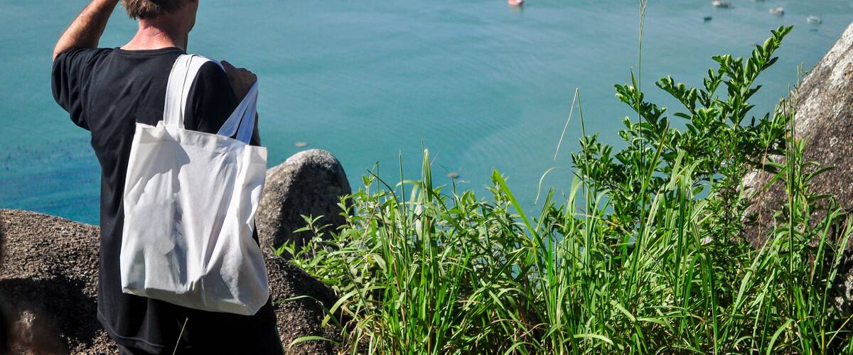 Tourist enjoying the panoramic view of Canto Grande Beach from Morro do Macaco viewpoint in Bombinhas, Santa Catarina, Brazil