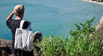 Tourist enjoying the panoramic view of Canto Grande Beach from Morro do Macaco viewpoint in Bombinhas, Santa Catarina, Brazil