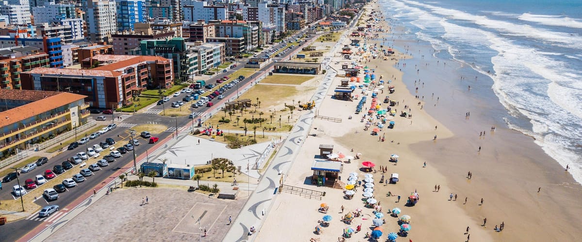 A coastal city with a beach, buildings, and a clear sky.
