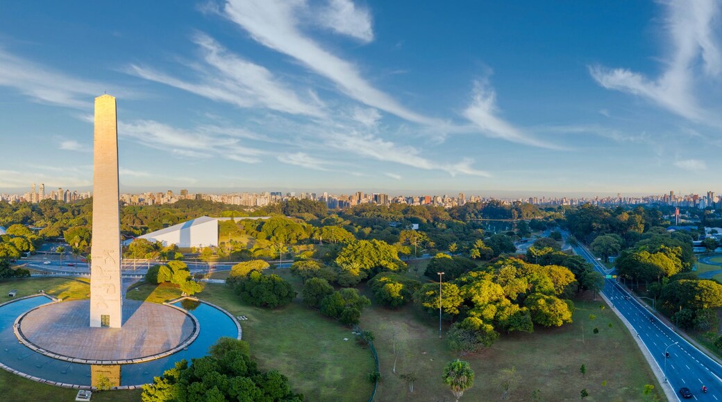 A cityscape with a prominent monument, dense urban buildings, and green spaces.