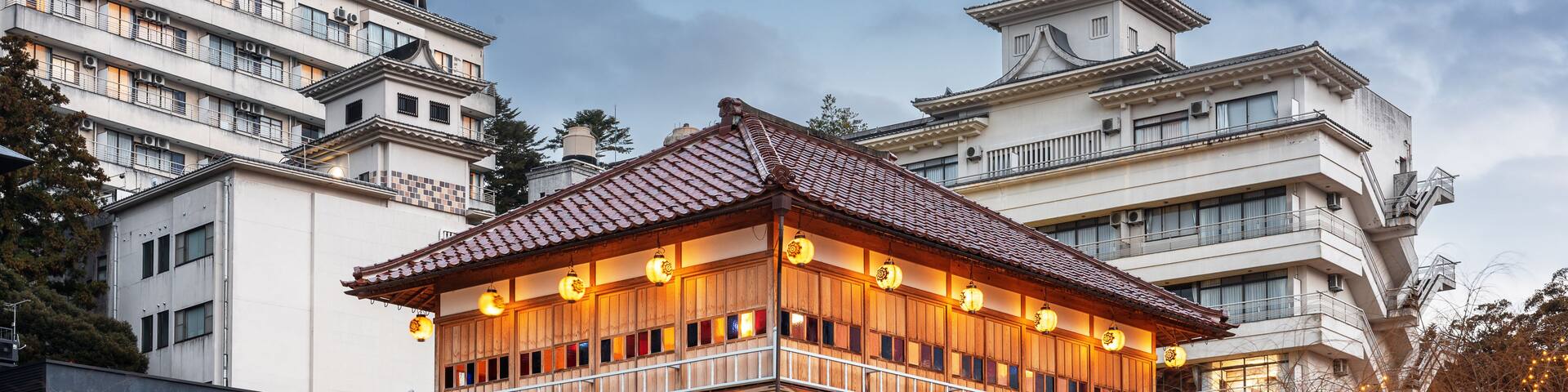 A traditional wooden building with a tiled roof, surrounded by modern high-rise buildings.