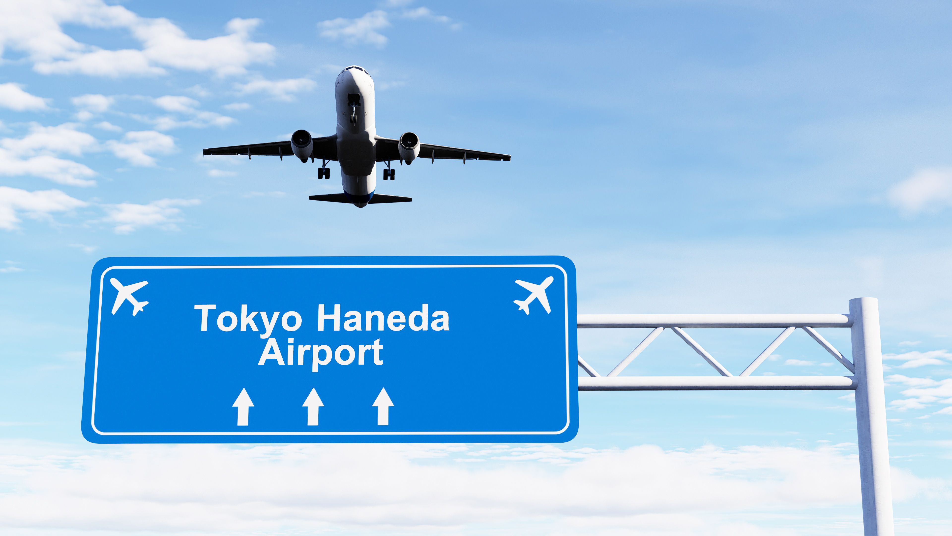 Un avión volando sobre un cartel de bienvenida a Aeropuerto de Haneda, Tokio.