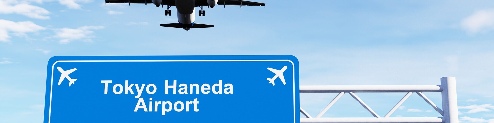 Un avión volando sobre un cartel de bienvenida a Aeropuerto de Haneda, Tokio.