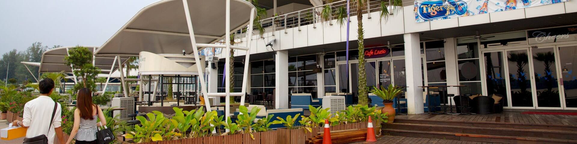 A modern building with a sign reading "Duke's Bar Marina Club" and a "Tiger" beer advertisement.