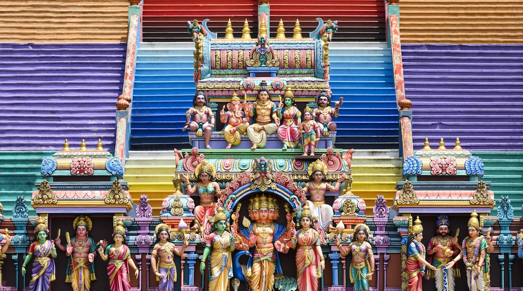 A colorful temple facade with intricate carvings and statues of deities.