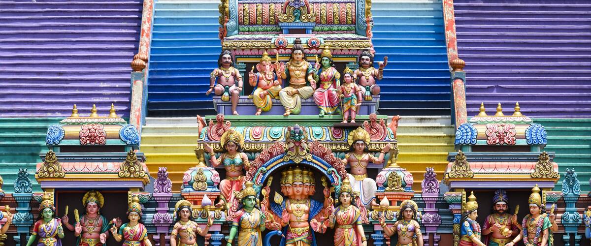 Une façade de temple aux couleurs vives, ornée de sculptures complexes et de statues de divinités.