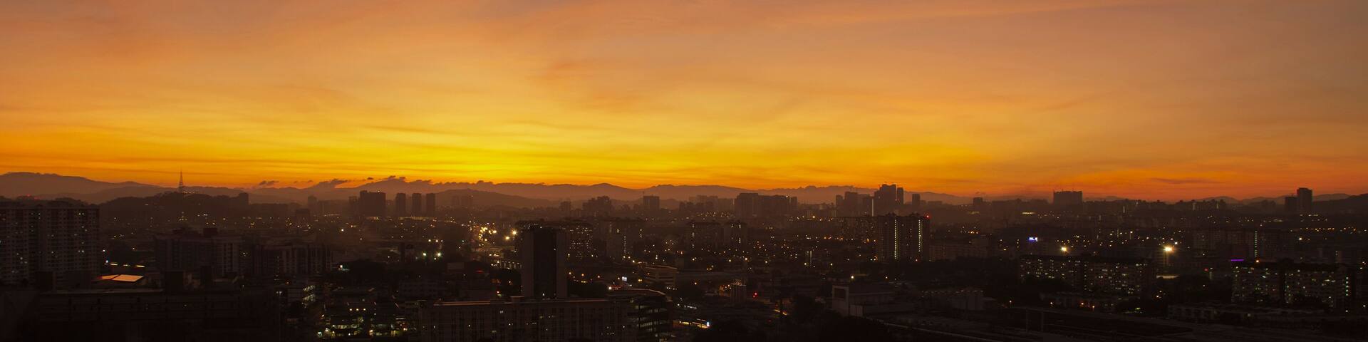 A city skyline at sunset with a gradient sky.