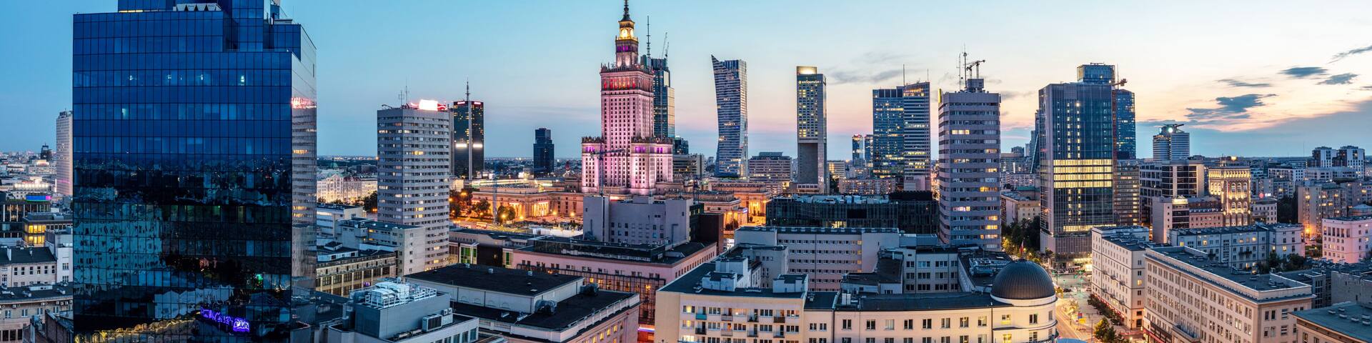 A cityscape with modern skyscrapers and a historic building with a spire.