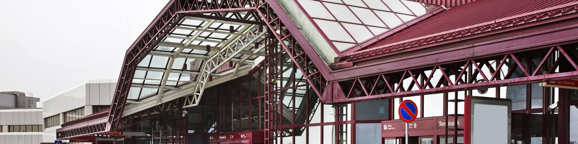 A bus terminal with a distinctive red and white metal roof structure.