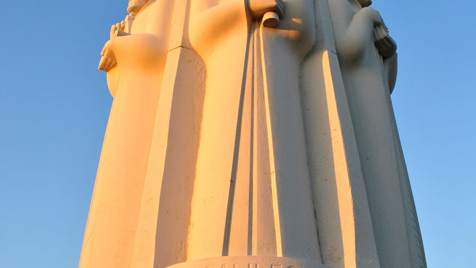 Een monument met drie beelden en de naam 'GALILEO' erop gegraveerd.
