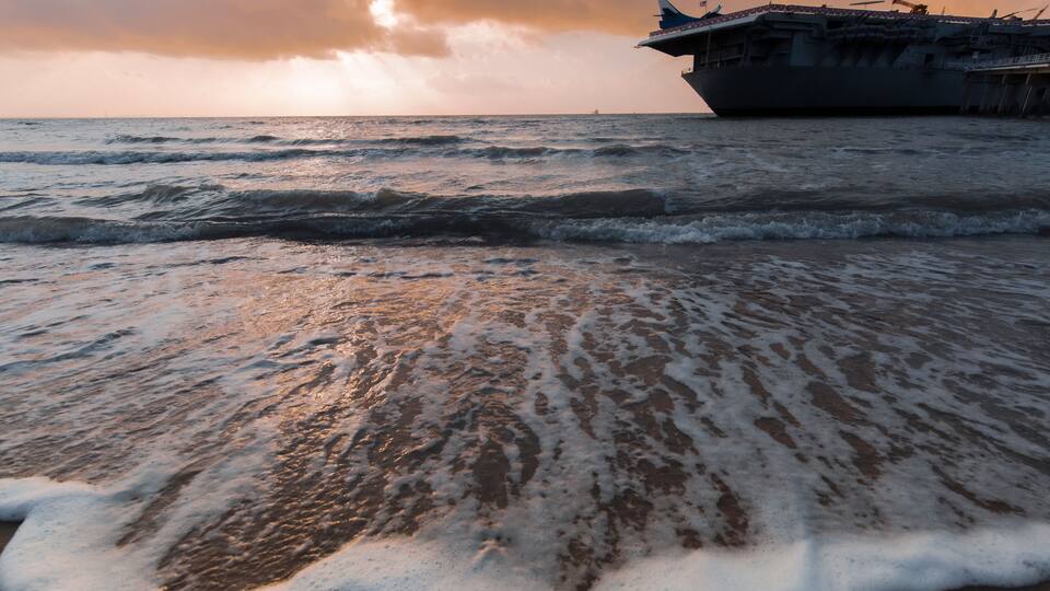 sunset ,North Beach in Corpus Christi, Texas, USA with aircraft carrier ship