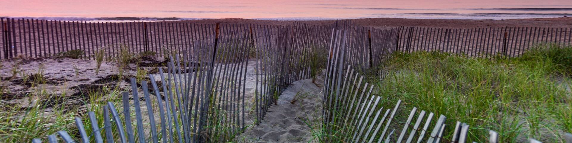 Old Picket Beach Fence During Sunrise At Salisbury Beach In Massachusetts