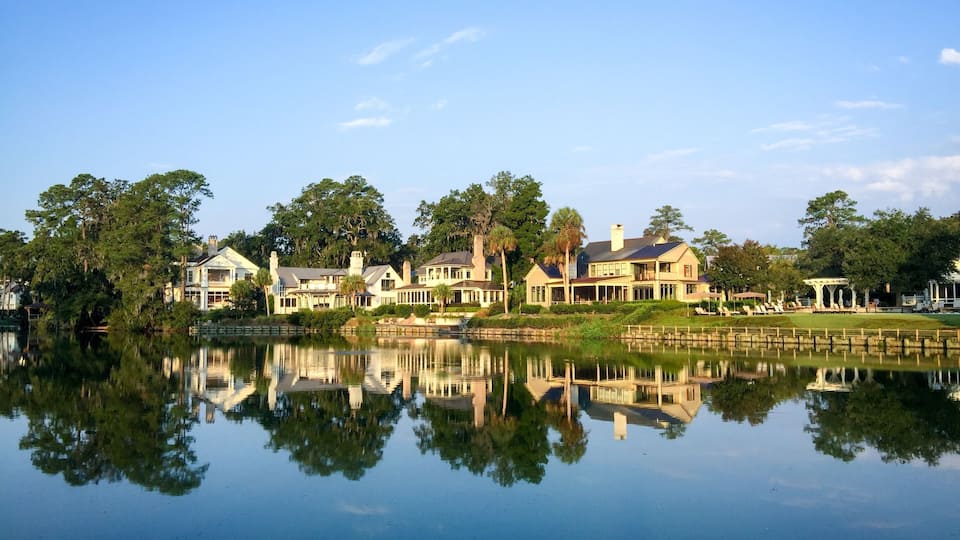 Reflection of lake houses and trees over still waters; Shutterstock ID 485074414; Purchase Order: -