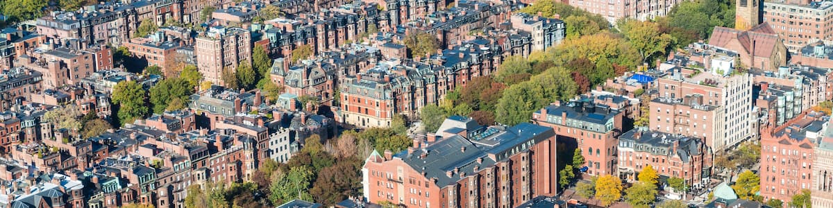 An aerial view of a densely packed urban area with historic buildings, a river, and a bridge.