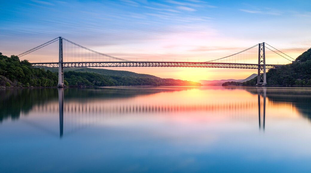 Bear Mountain Bridge at sunrise (long exposure). Bear Mountain Bridge is a toll suspension bridge in New York State, carrying U.S. Highways 202 and 6 across the Hudson River