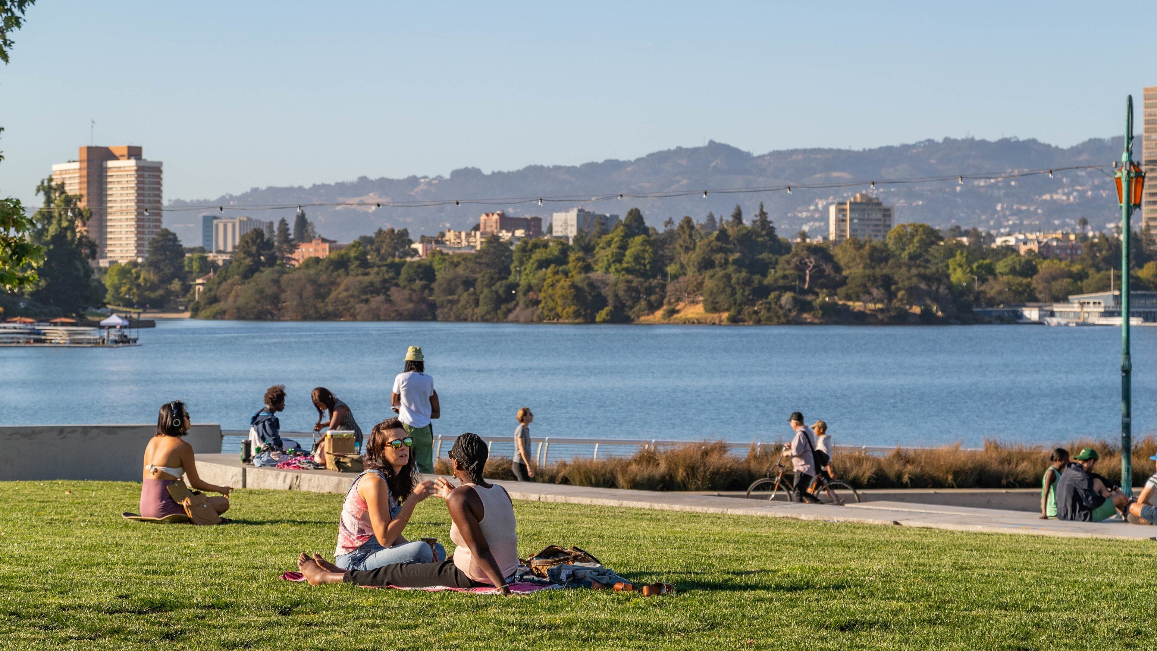 Lake Merritt featuring a park and a lake or waterhole as well as a couple