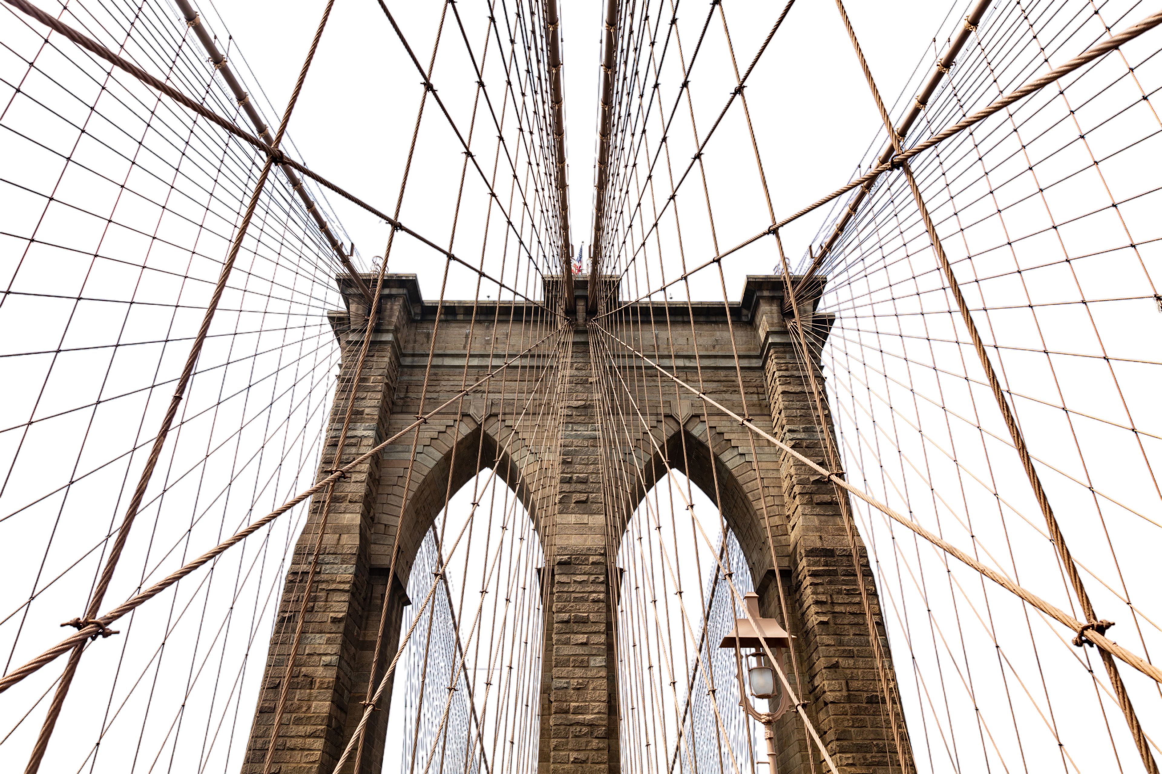 The Brooklyn Bridge's stone arches and suspension cables.