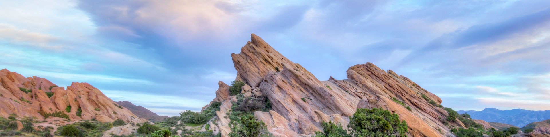 Un paisaje desértico con formaciones rocosas destacadas y vegetación escasa.