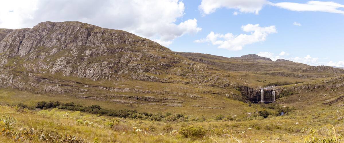 A mountainous landscape with a waterfall.