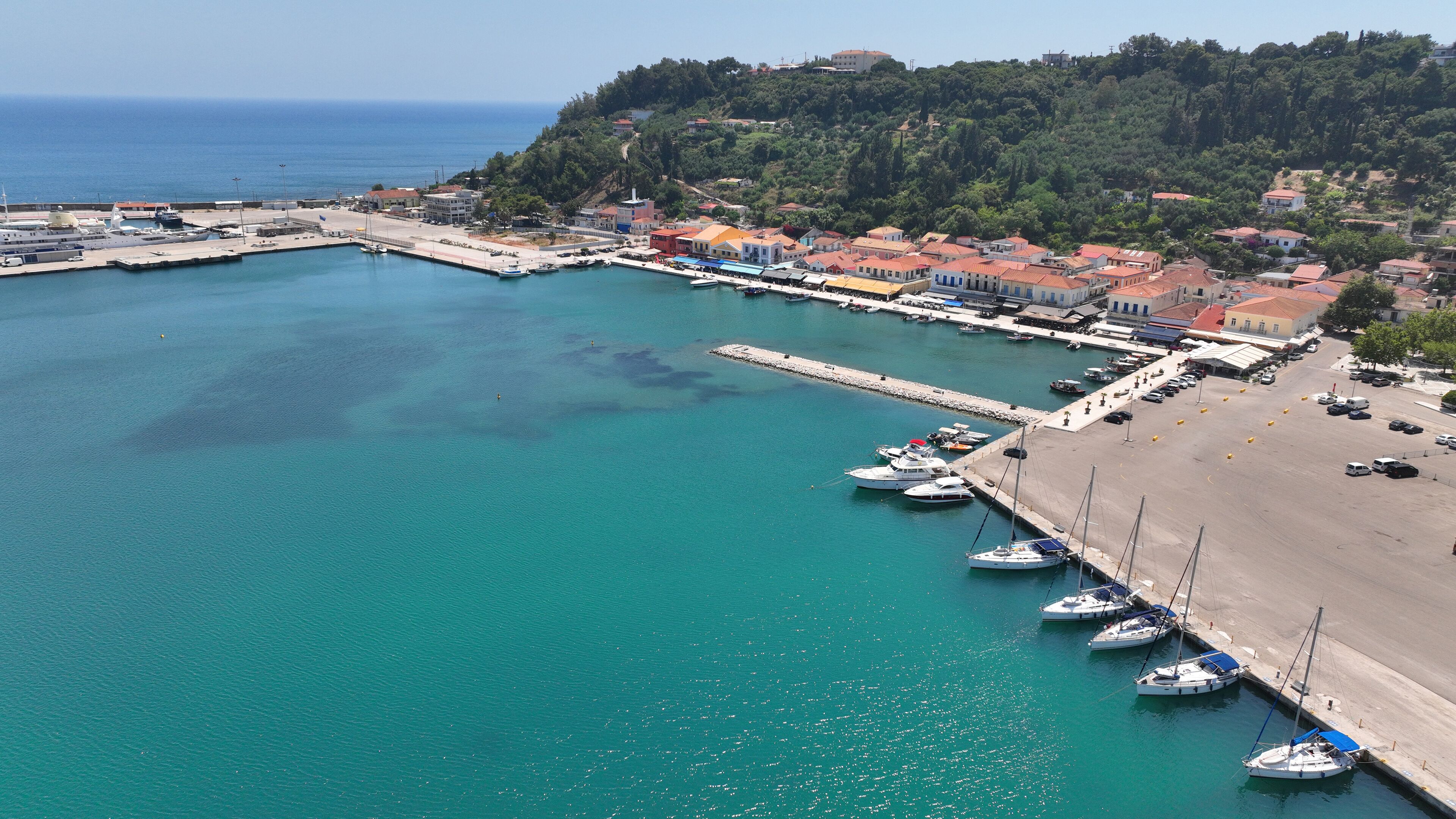 A coastal town with a marina, boats, and a beach.