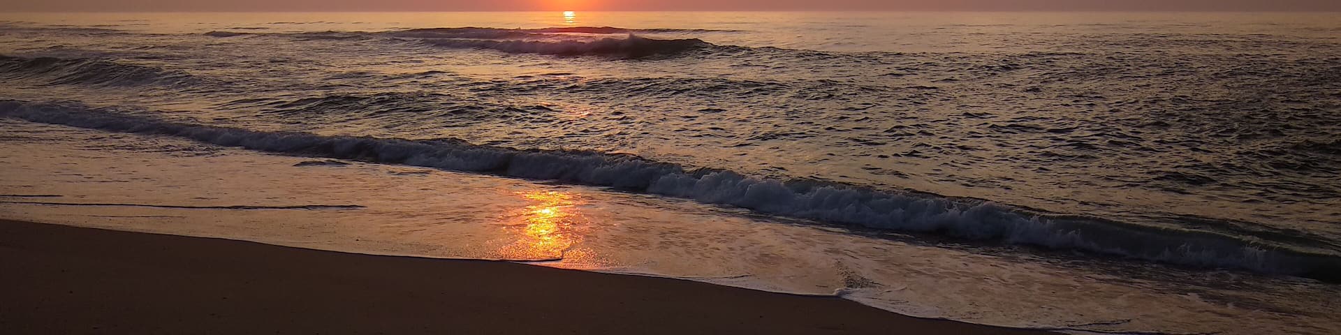 Beautiful autumn sunset over the Atlantic ocean in Quiaios Beach, Portugal with dramatic cloudy sky. Nature photography in warm tones taken at dusk